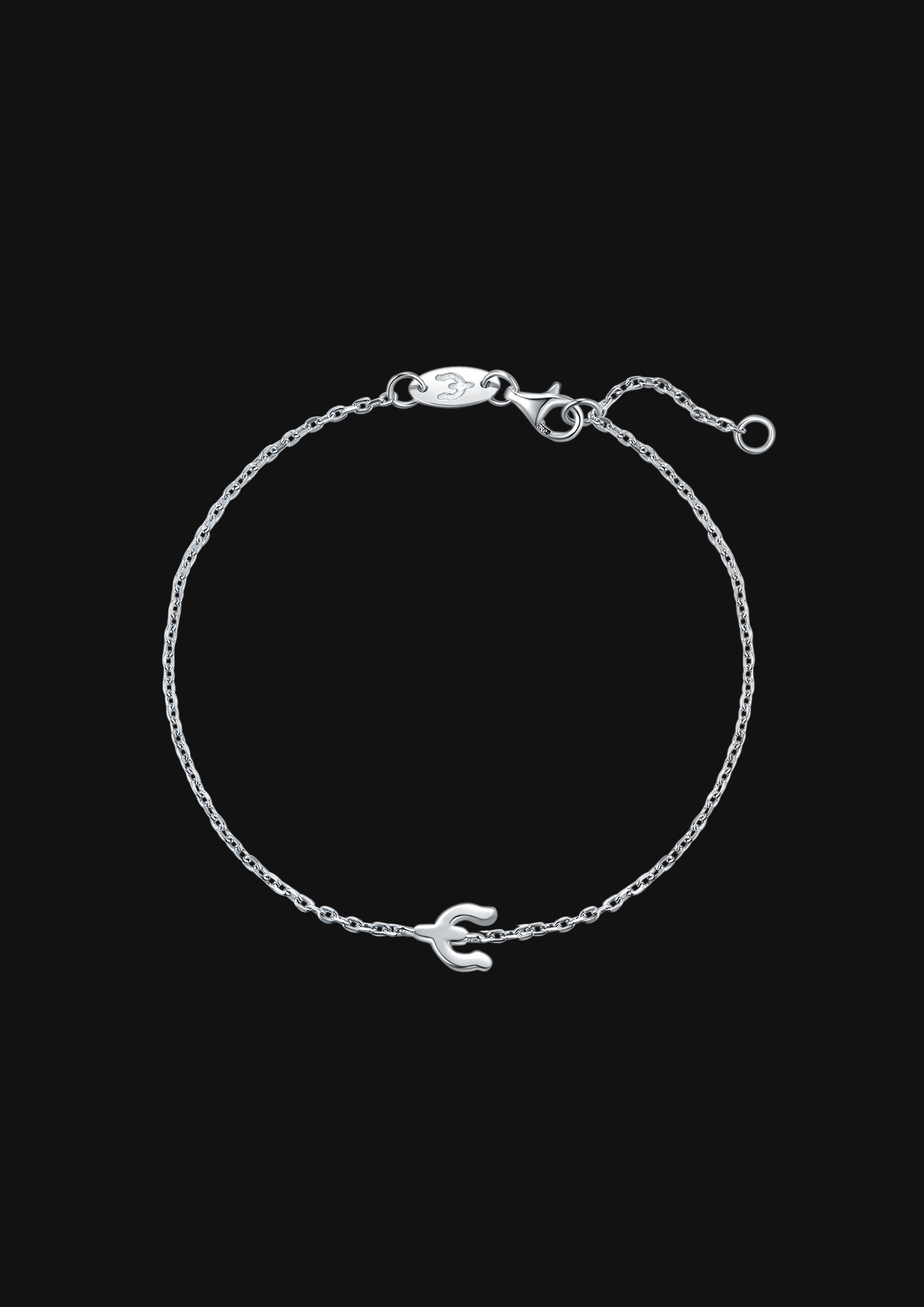 Silver bracelet with a small charm on a black background
